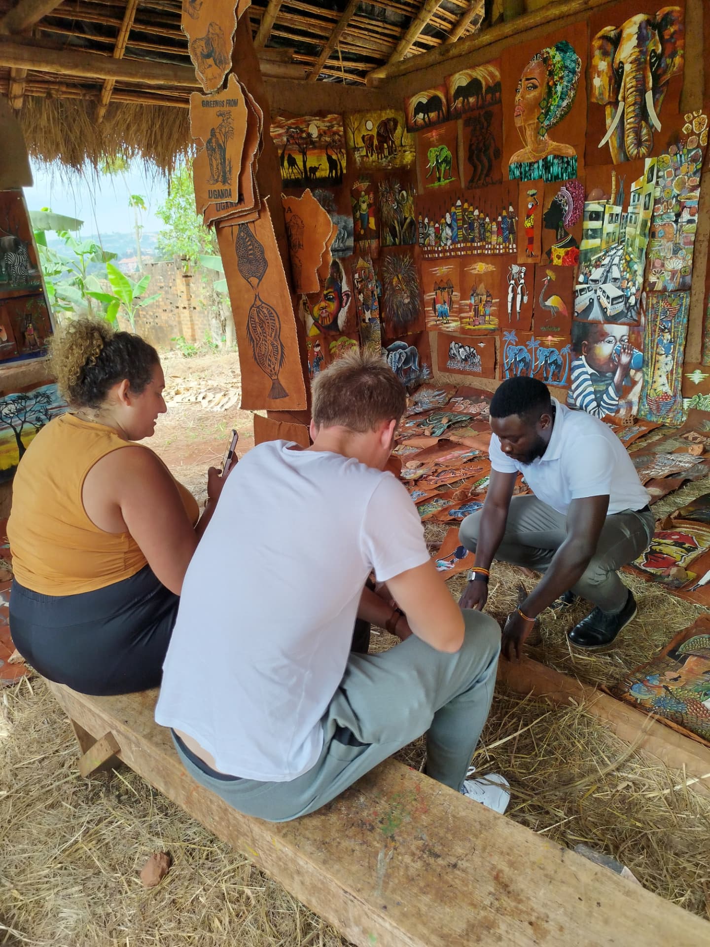 Visitors browsing traditional bark-cloth artwork at a Buganda cultural stall