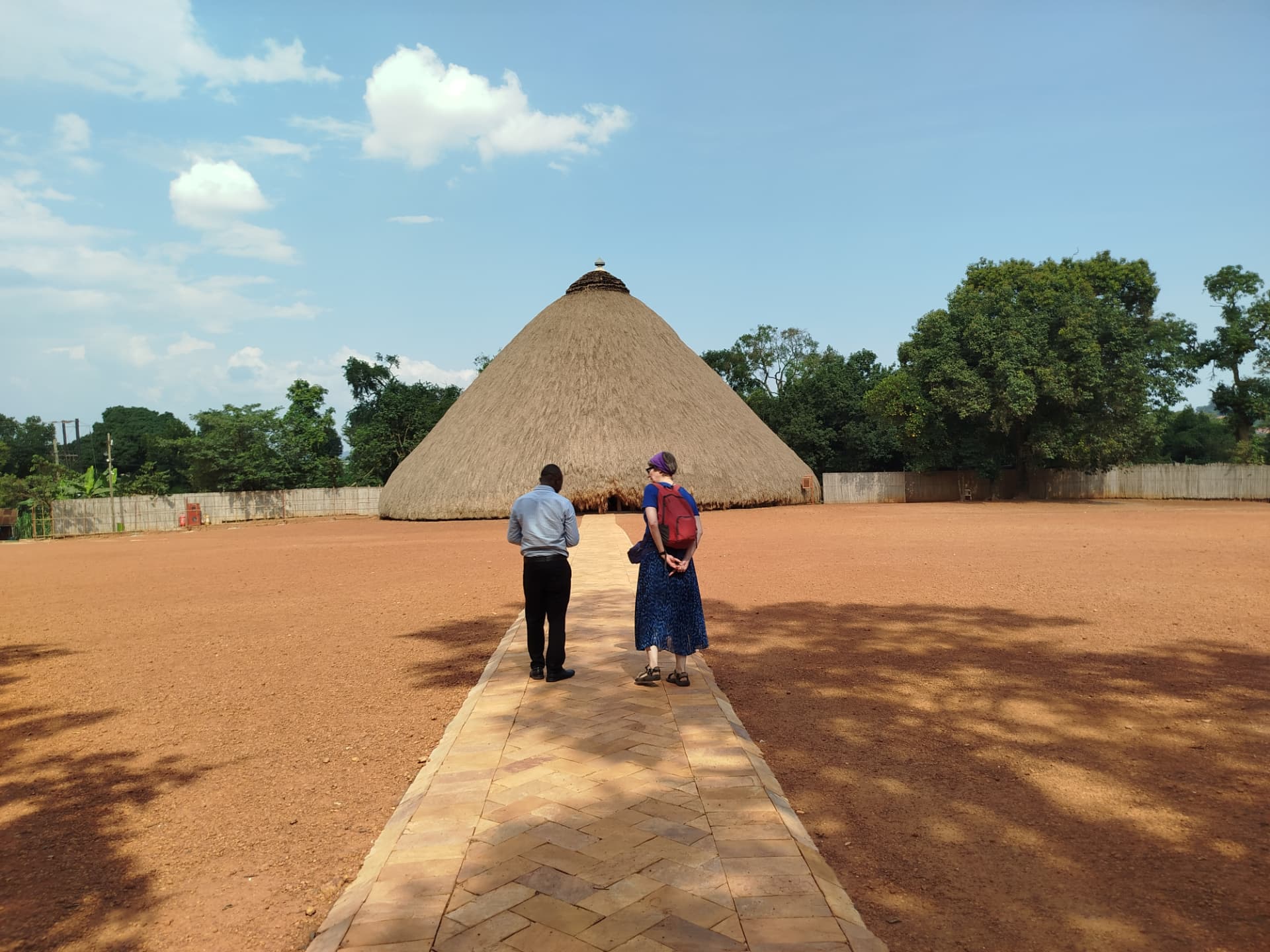 Two visitors walking toward the Kasubi Tombs on the Buganda Cultural Experience